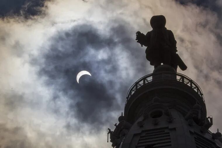The statue of William Penn is silhouetted by the solar eclipse at 2:30 pm on Monday August 21, 2017. The clouds in the sky helped viewers to watch the eclipse and create a unique view. But clouds of secrecy have long obscured workplace sexual harassment. MICHAEL BRYANT / Staff Photographer