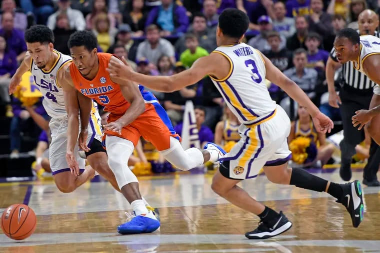 LSU guard Skylar Mays (4), Florida guard KeVaughn Allen (5) and LSU guard Tremont Waters (3) chase the ball in overtime of an NCAA college basketball game Wednesday, Feb. 20, 2019, in Baton Rouge, La. Florida won 82-77. (AP Photo/Bill Feig)