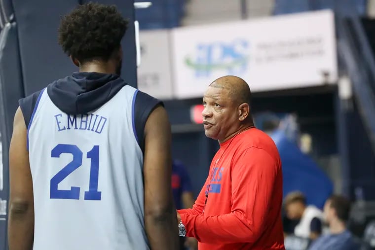 Joel Embiid speaks with coach Doc Rivers after practice on the second day of Sixers training camp at The Citadel in Charleston, S.C.