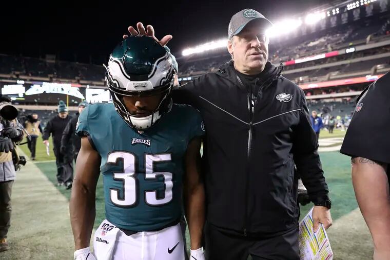 Eagles coach Doug Pederson consoles running back Boston Scott as they leave the field after the loss to the Seahawks.