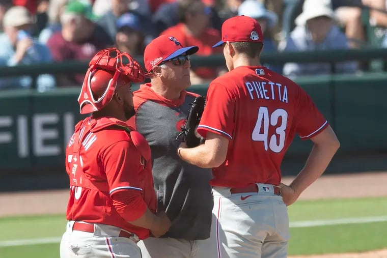 Phillies starter Nick Pivetta listens to pitching coach Bryan Price in a mound meeting in the second inning of Saturday's 8-8 tie with the Detroit Tigers at Joker Marchant Stadium in Lakeland, Fla.