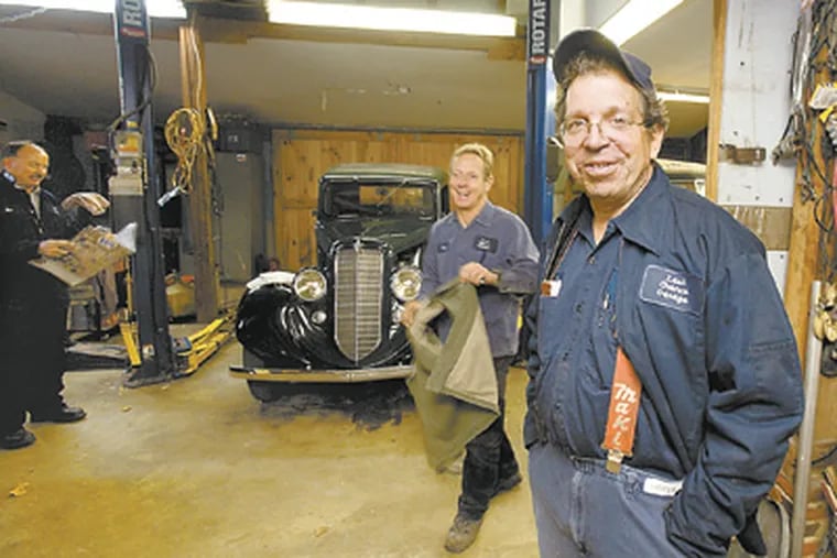 Lou Mandich in his Last Chance Garage with Jim Groome (left) and Fred Shufflebarger. Mandich gave up teaching to work on and restore classic cars in Unionville, Chester County. (Ed Hille / Staff Photographer)