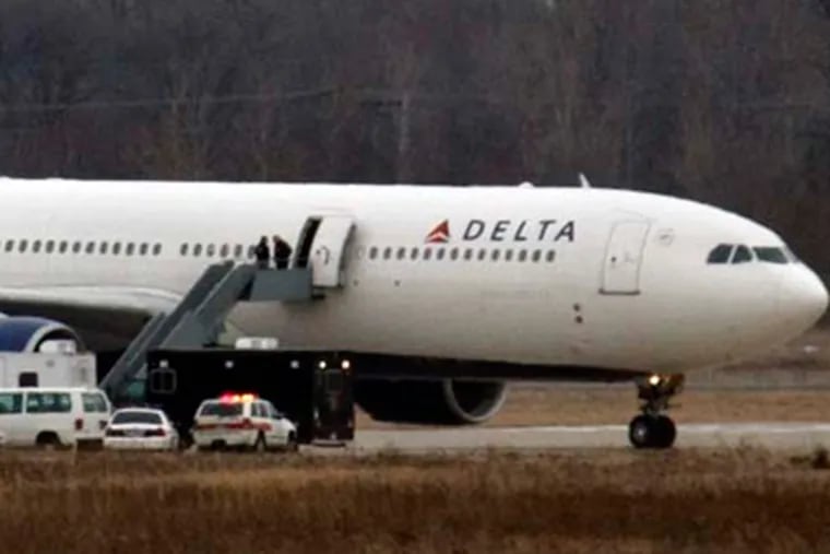The Delta-Northwest Airlines plane N820NW is pulled back to the terminal at the Detroit Metropolitan airport in Romulus, Mich., after a passenger set off an explosive device Friday in a failed terrorist attack. (AP Photo/Carlos Osorio)