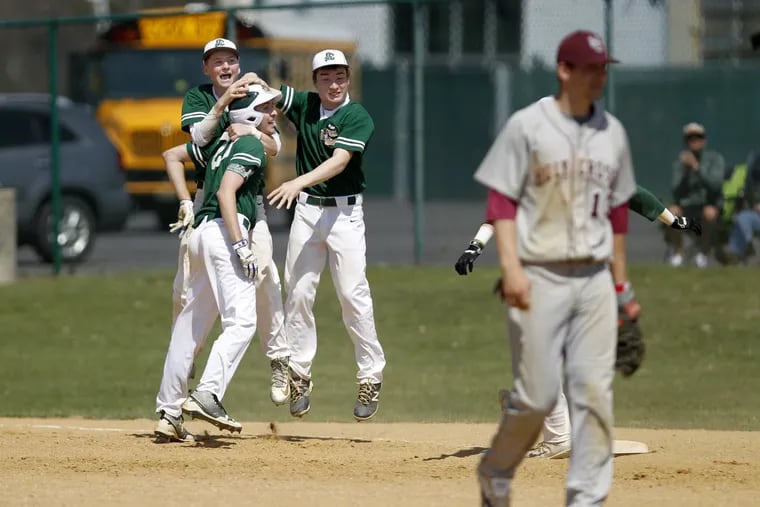 Camden Catholic’s Tom Cava (23) celebrates with Shane Colfer (left) and Sam Kasilowski after he knocked in the game-winning run against Holly Cross.