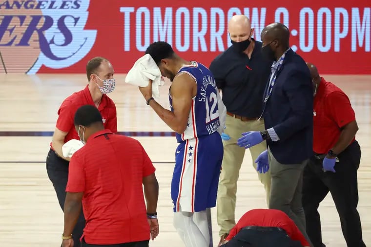 Philadelphia 76ers forward Tobias Harris (12) is attended to after hitting his head against the Boston Celtics during the third quarter of Game 4 of an NBA basketball first-round playoff series, Sunday, Aug. 23, 2020, in Lake Buena Vista, Fla. (Kim Klement/Pool Photo via AP)