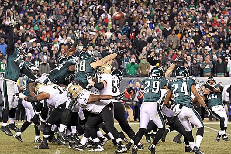 Eagles special team members try to block the Saints' game-winning field goal attempt as fans watch. (Yong Kim/Staff Photographer)