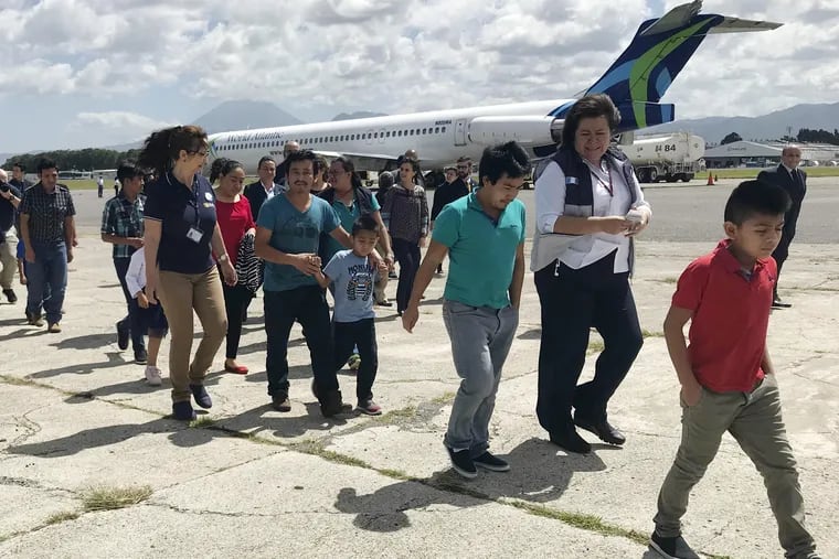 Families separated under President Donald Trump administration's zero tolerance policy return home to Guatemala City, Guatemala, on Tuesday after being deported from the United States. After lining up on the tarmac, they headed to a processing center where they were screened and given identification before being released back into the country.