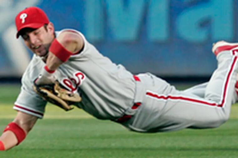 Phillies centerfielder Aaron Rowland dives for a catch off Kelly Johnson in the third. The game began as a pitcher&#0039;s duel between Jon Lieber and Tim Hudson.