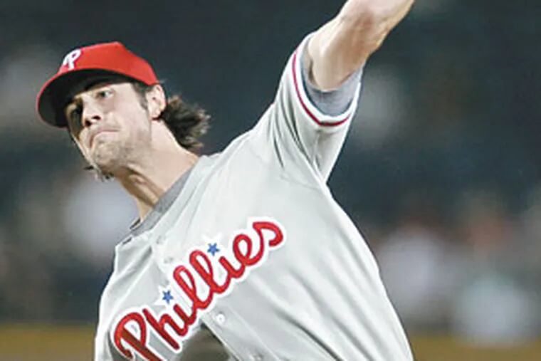 Cole Hamels throws to Atlanta Braves' Chris Woodward in the fourth inning.