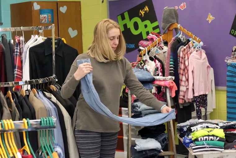 Allison Laurence, a health and physical education teacher who helped set up the Legacy Center at Pinelands Regional Junior High School, folds donated items available for people that need them at the school in Little Egg Harbor Township, N.J.