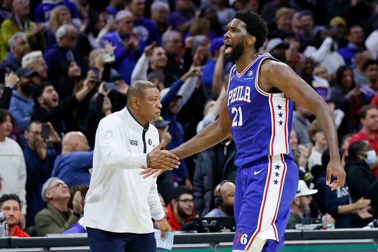 Sixers center Joel Embiid yells while shaking hands with Head Coach Doc Rivers against the Atlanta Hawks on Monday.