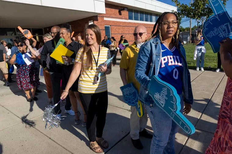 School staff wait to greet incoming students for the start of school at Morgan Village Middle School in Camden.