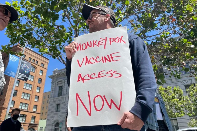A man holds a sign urging increased access to the monkeypox vaccine during a protest in San Francisco on July 18.