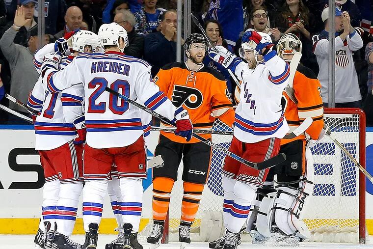 The New York Rangers celebrate after a third period goal by center Derek Stepan against the Philadelphia Flyers during an NHL hockey game, Sunday, Feb. 14, 2016, in New York. The Rangers won 3-1.