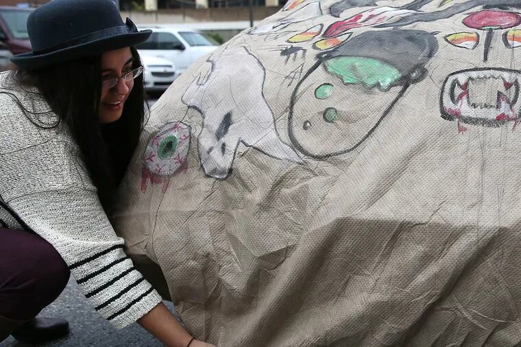 Artist Holiday Campanella adjusts the car cover she designed for the EmpireCover Halloween Car Cover Contest in Philadelphia on October 23, 2014. ( DAVID MAIALETTI / Staff Photographer )