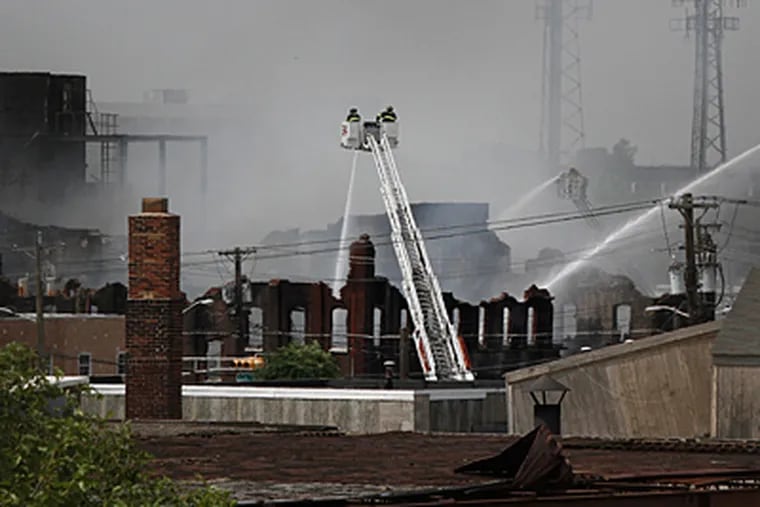 In a view from the State Street bridge, three master streams are in operation as firefighters fight a blaze at the old Concord Chemical Co., on Federal Street in Camden. (Elizabeth Robertson / Staff)