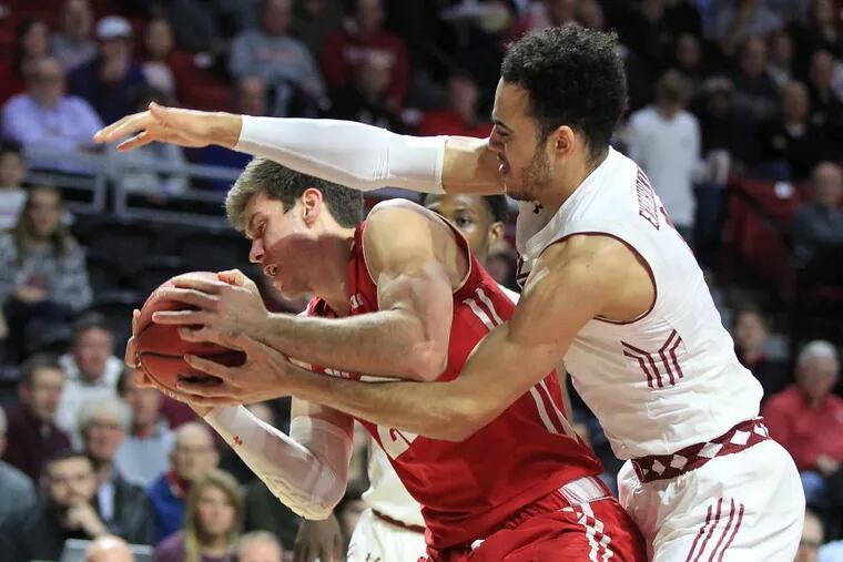 Wisconsin star Ethan Happ  (left)  fights for a rebound with Obi Enechionyia of Temple in the first half.