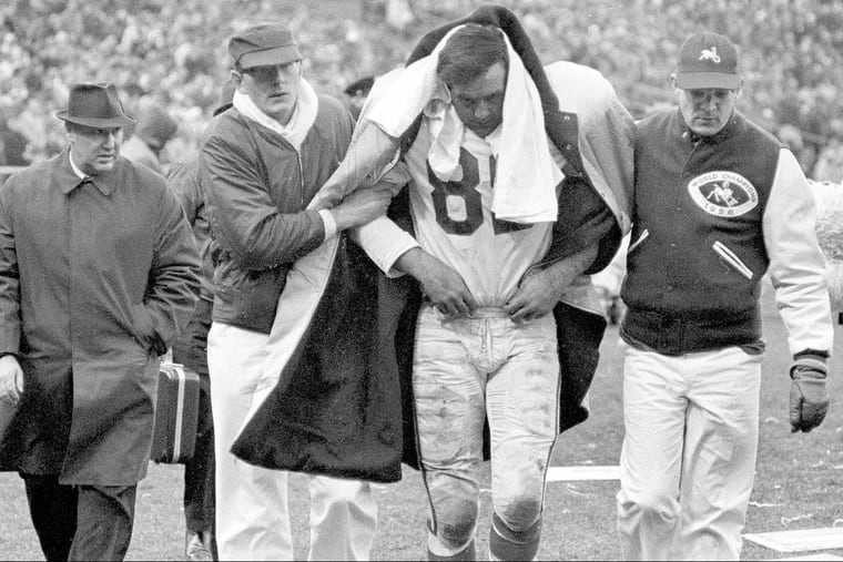 Gino Marchetti, Baltimore Colts all-pro defensive end, is helped off the field during a game with the Detroit Lions in Baltimore on Dec. 6, 1964. The team physician said Marchetti had suffered a concussion. Contemporary NFL concussions were the focus of a federal hearing in Philadelphia on Wednesday, May 30, 2018.