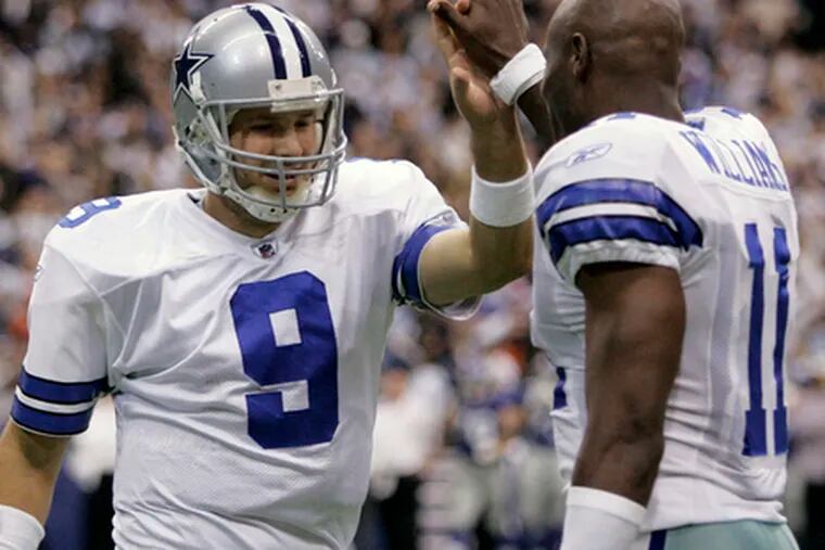 Dallas wide receiver Roy Williams (right) and Tony Romo exchange high fives during a game against the Giants. Williams, who has 194 receiving yards this year, longs for more catches.