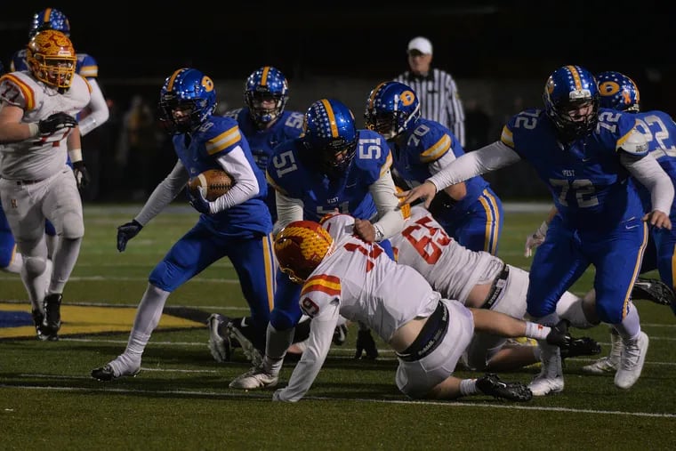 Alex Rosano (6) of Downingtown West following the block of teammate Drew Shelton (51) in the District 1 Class 6A semifinals vs. Haverford High. Downingtown West won the game, 49-42.