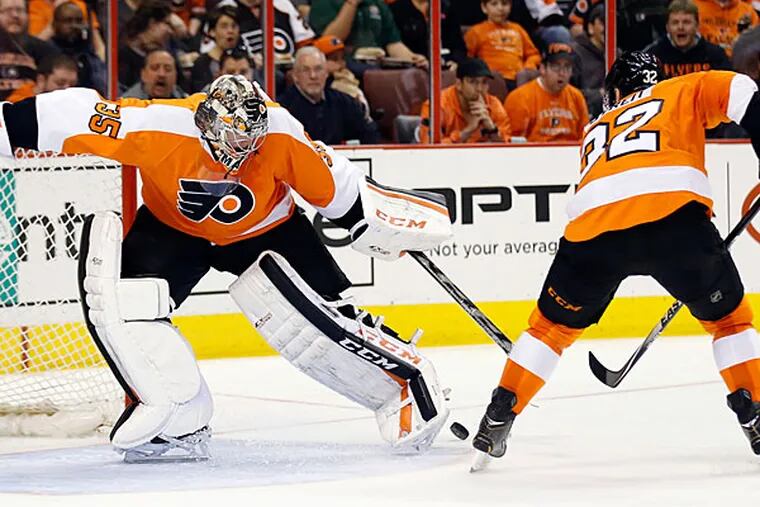 Steve Mason and Mark Streit watch the puck fall between them against the Blue Jackets. (Yong Kim/Staff Photographer)