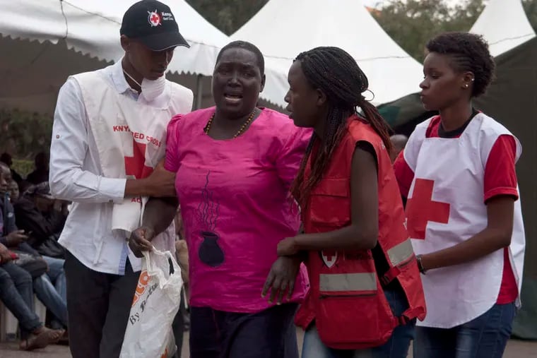 Red Cross staff members outside a funeral home in Nairobi on Saturday try to console a woman who had just viewed the body of a relative killed in Thursday's attack at a university. Nearly 150 people were killed.