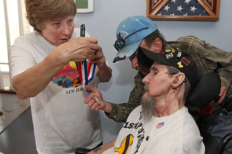 Gerri Gsell and Fred Gsell, wife and brother of Robert Gsell, center, show Robert his Gloucester County Military Medal on May 12, 2014. (Michael Bryant / Staff Photographer)