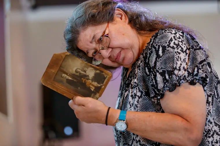 Christina Fraker looks at the back of an old family photograph at the Negro Family reunion held in South Philadelphia.