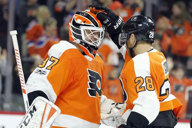 Flyers Brian Elliott (left) and Claude Giroux celebrate the 2-1 win over the Edmonton Oilers on Saturday.