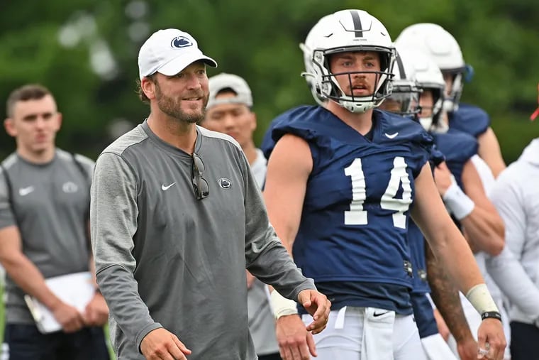 Penn State quarterback Sean Clifford stands with offensive coordinator and quarterbacks coach Mike Yurcich  during practice on Aug. 7, 2021.