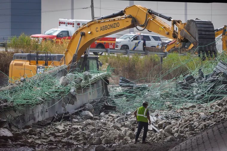 An excavator removes debris Monday from the site of the collapsed portion of I-95 on Cottman Avenue in Northeast Philadelphia. Repairing the highway is expected to take months.