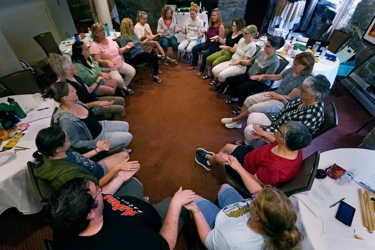 Teachers join in a circle during a workshop helping to find a balance in their curriculum while coping with stress and burnout in the classroom, Tuesday, Aug. 2, 2022, in Concord, N.H.