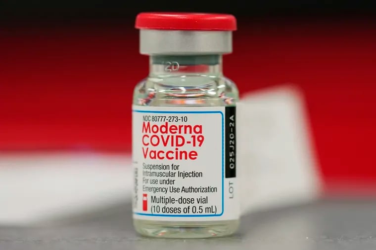 A vial of the COVID-19 vaccine from Moderna sits on a table.