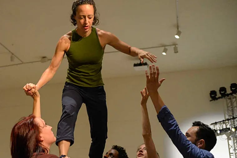 At Crane Arts' Icebox space, Bethany Formica is supported by other dancers during a dress rehearsal for &quot;Supper, People on the Move,&quot; a multimedia project on the immigrant experience. (BEN MIKESELL / Staff Photographer)
