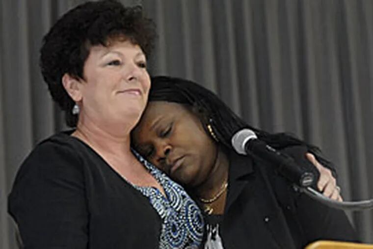 At the Sheet Metal Workers Hall, Dwanda Roberts, whose husband, Jon Roberts, was killed at work at the Philadelphia Airport, rests her head on the shoulder of Irene Snyder, President of AFSCME Local 1510. (April Saul/Inquirer)