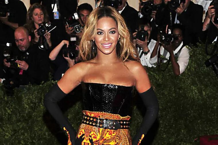 FILE - This May 6, 2013 file photo shows singer Beyonce at The Metropolitan Museum of Art's Costume Institute benefit in New York.  Beyonce has released her new album in an unconventional way: She announced and dropped it on the same day. The singer released "Beyonce" exclusively on iTunes early Friday, Dec. 13.  (Photo by Charles Sykes/Invision/AP, File)