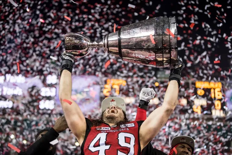 The Calgary Stampeders' Alex Singleton hoists the Grey Cup after the Stampeders defeated the Ottawa Redblacks in Grey Cup in Edmonton, Alberta, last November.