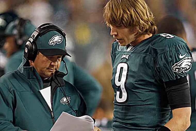 Eagles quarterback Nick Foles and offensive coordinator Marty Mornhinweg talk over plays on the sidelines. (Yong Kim/Staff Photographer)