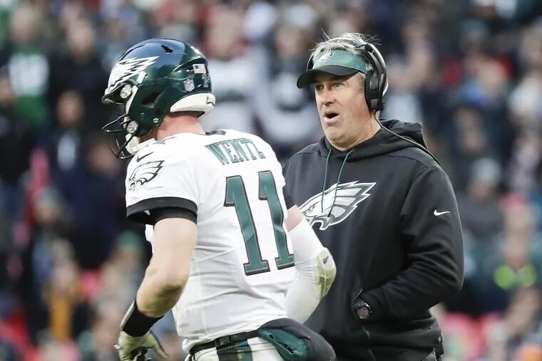 Eagles head coach Doug Pederson looks over at quarterback Carson Wentz late in the fourth-quarter against the Jacksonville Jaguars at Wembley Stadium in London on Sunday, October 28, 2018. YONG KIM / Staff Photographer