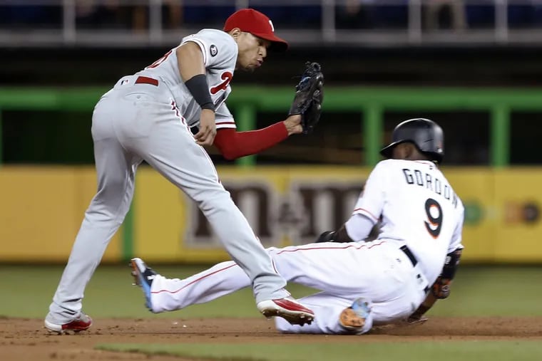 Phillies second baseman Cesar Hernandez, left, tags out Dee Gordon as he tries to steal second base during the first inning.