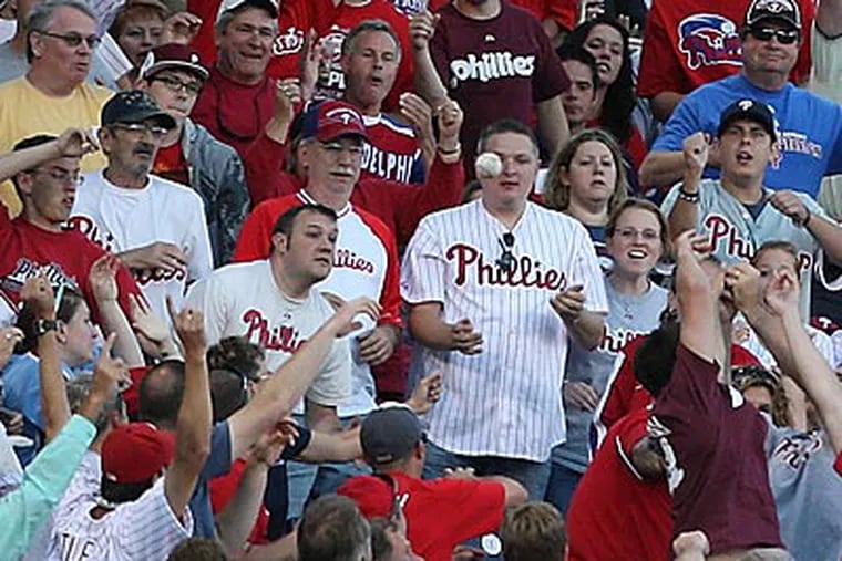 Fans try to catch Ryan Howard's two-run home run in the second inning. (David M Warren / Staff Photographer)