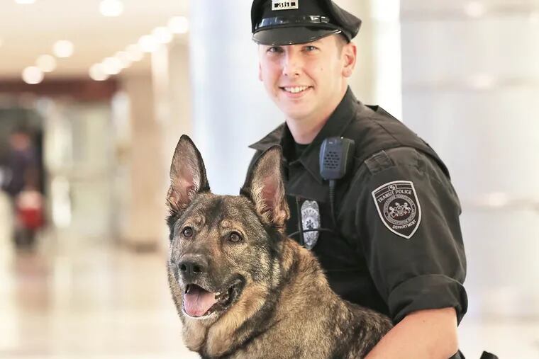 SEPTA Police Officer Jason Walters is a K-9 cop whose partner, Winchester, was a rescue dog. Their partnership has proven so successful that Walters has created a charity, the Throw Away Dogs Project, that aims to train unwanted shelter dogs as working service dogs. They are pictured at Suburban Station in Philadelphia on August 12, 2014.  DAVID MAIALETTI / Staff Photographer
