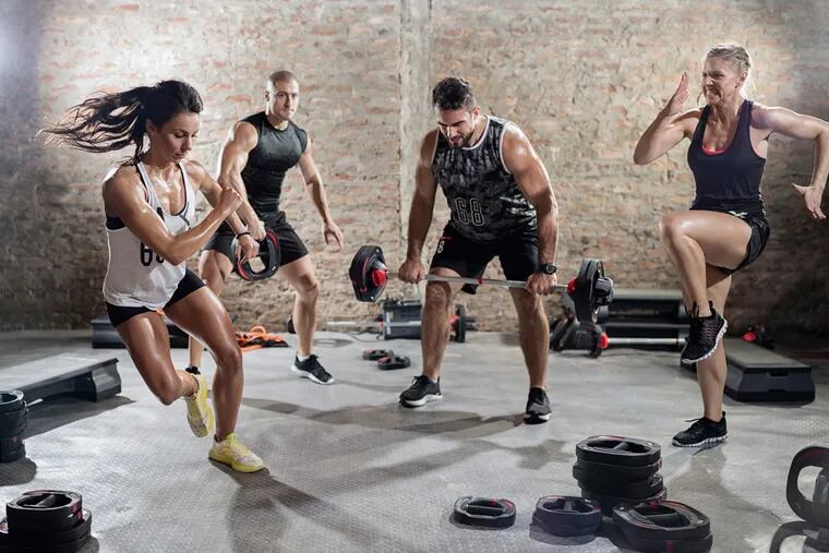 Gym-goers perform HIIT exercises.