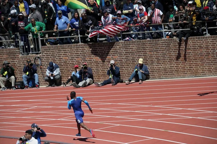 Fans cheer as Team USA Red's Je'von Hutchison leads in the final leg of the USA vs. the World men's 4x400 race during the 125th annual Penn Relays at Franklin Field in Philadelphia on Saturday, April 27, 2019. Team USA Red won the event.