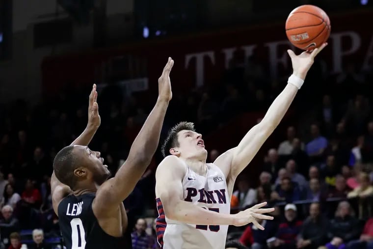 Penn forward AJ Brodeur (right) drives to the basket past Harvard forward Chris Lewis in the first-half of Friday's overtime win for the Quakers.