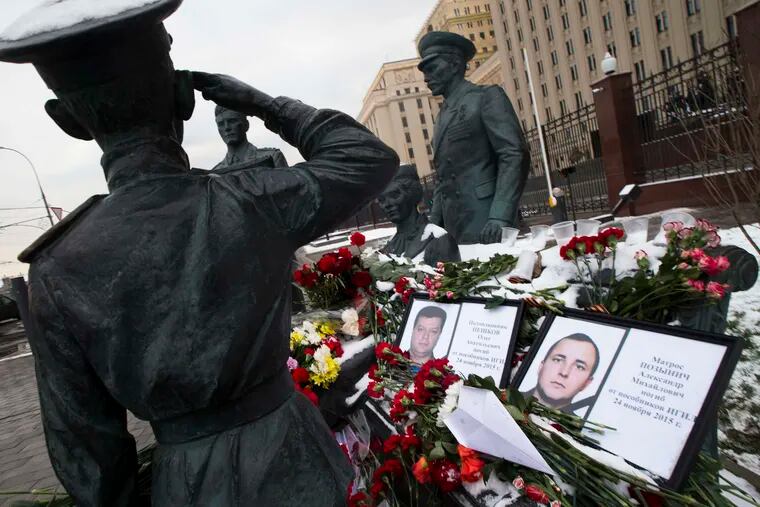 Photos of Lt. Col. Oleg Peshkov (left) and sailor Alexander Pozynich join a monument to Soviet officers in Moscow. Peshkov was a pilot shot down along Turkey's border, and Pozynich died in an attempted rescue.