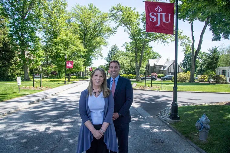 Interim St. Joseph's University President Cheryl McConnell with former president Mark C. Reed, on the Hawk Hill campus in 2022 just before the merger became final.