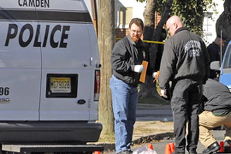 Police investigate the scene of the shooting, on Morton Street in Camden. (Tom Gralish/Inquirer)