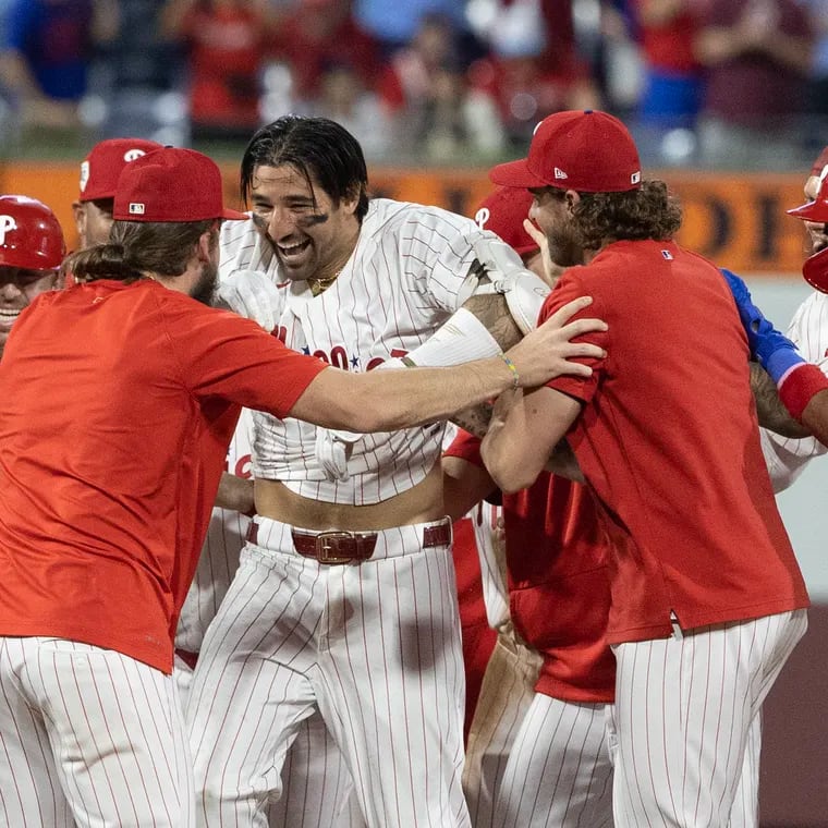 Nick Castellanos, center, of the Phillies is swarmed by teammates after driving in the game-winning run in the 10th inning on June 4, 2024 at Citizens Bank Park.