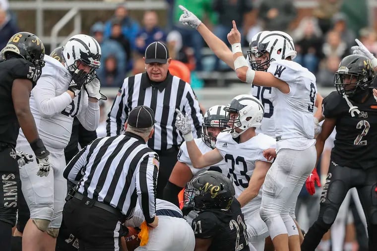 The officials look at one another while determining which team recovered a fumble during a PIAA semifinal game between Neumann Goretti and Wyomissing at the Germantown Supersite on Dec. 3.